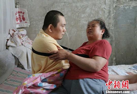 身體日漸衰老的梁青蘭每次幫兒子翻身、坐立，全身的衣物都要濕透一次?！∩忻鱾b 攝