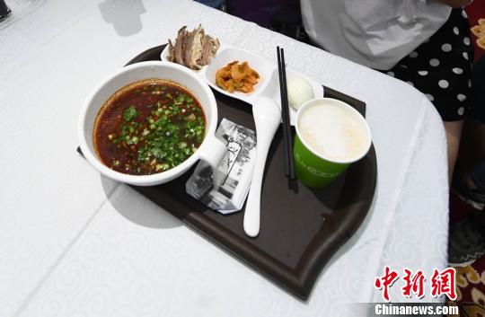 圖為&ldquo;環(huán)西部火車游Y667/8次&rdquo;列車上推出蘭州牛肉面套餐，套餐38元，有一碗牛肉面、一碟牛肉、一個(gè)雞蛋、一份小菜、一份甜胚子。　楊艷敏 攝