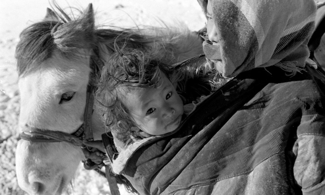 1990年3月，西藏當(dāng)雄縣納木湖鄉(xiāng)三村女牧民斯卓不畏嚴(yán)寒，懷抱幼子，準(zhǔn)備到遠(yuǎn)處放牧。新華社記者覺(jué)果攝