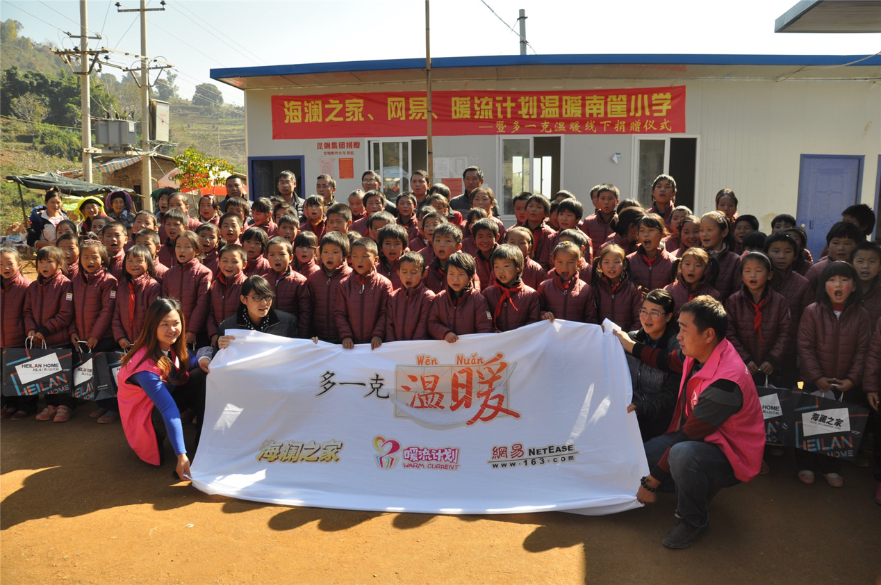 2014年11月20日，&ldquo;多一克溫暖&rdquo;公益團隊來到8.3大地震的重災區(qū)&mdash;&mdash;云南省昭通市魯?shù)榭h的南筐小學。越過崎嶇山路，將一批又一批暖心羽絨服送到了師生們的手中，也將社會的關懷和愛意傳遞給了這些可愛的人。