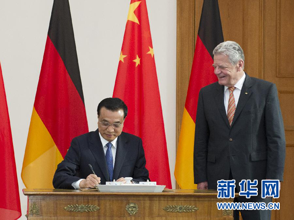 10月10日，國務(wù)院總理李克強在柏林會見德國總統(tǒng)高克。這是李克強總理在高克總統(tǒng)的陪同下在貴賓簿上簽字。 新華社記者 王曄 攝 
