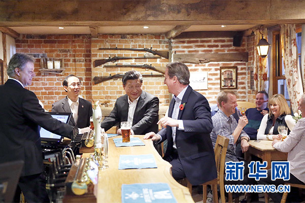 這是會(huì)晤結(jié)束后，習(xí)近平在卡梅倫陪同下乘車前往當(dāng)?shù)匦℃?zhèn)體驗(yàn)酒吧文化。新華社記者 鞠鵬 攝